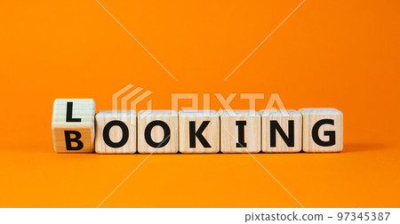 Looking and booking symbol. Turned the wooden cube and changed the word 'looking' to 'booking'. Beautiful orange background, copy space. Business, looking and booking concept. 97345387