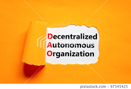 DAO decentralized autonomous organization symbol. Concept words DAO decentralized autonomous organization on white paper on a orange background. Business and DAO concept. Copy space. 97345425