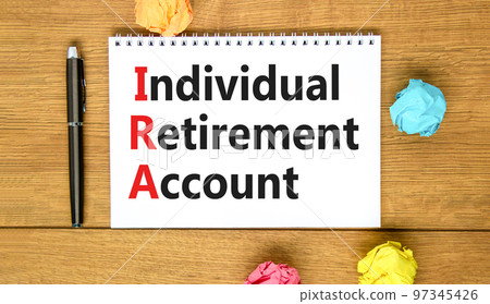 IRA individual retirement account symbol. Concept words IRA individual retirement account on white note on a beautiful wooden background. Business IRA individual retirement account concept. Copy space IRA individual retirement account symbol. Concept words IRA individual retirement account on white note on a beautiful wooden background. Business IRA individual retirement account concept. Copy space 97345426