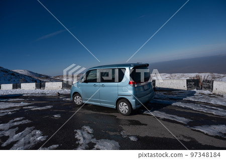 Blue car on the observation deck in the mountains.  97348184