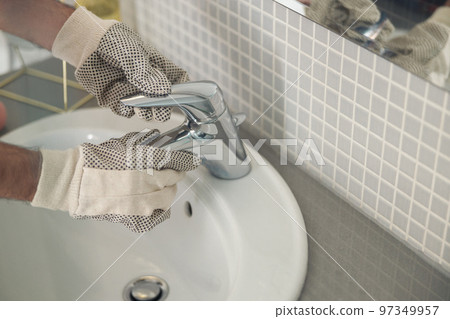 Close up of plumber is repairing faucet of a sink at bathroom. Good quality plumbing company service 97349957
