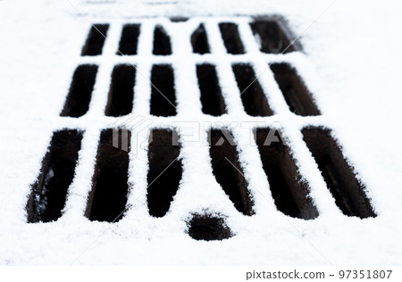 Drain grate covered with snow. Drain grate covered with snow. 97351807