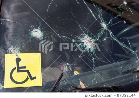 Bullet holes in the windshield of the car. Bullet holes in the windshield of the car. 97352144