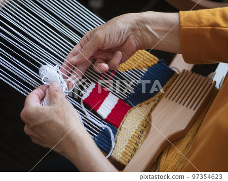 Making a tapestry with an image of lighthouse. Creating handmade wall decoration using weaving loom, beater and threads 97354623