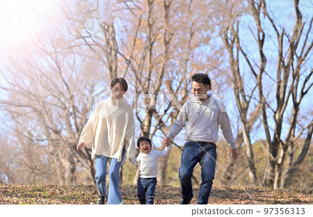 A portrait of a family walking hand in hand Autumn/Winter A portrait of a family walking hand in hand Autumn/Winter 97356313