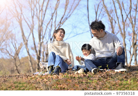 秋冬公園裡一家人微笑的畫像 97356318