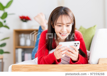年輕女子在客廳看智慧型手機 97359288