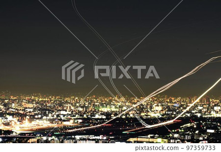 Night view of Osaka Airport Airplanes taking off and landing Intersecting light trails 97359733