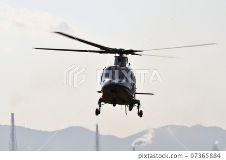 A helicopter taking off with its rotor spinning in the evening light 97365884