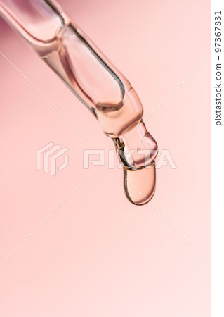 A drop of cosmetic oil falls from the pipette 97367831