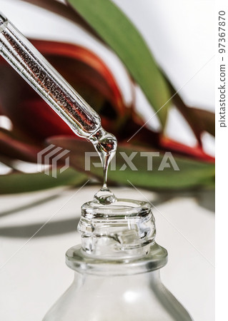 A drop of cosmetic oil falls from the pipette A drop of cosmetic oil falls from the pipette 97367870