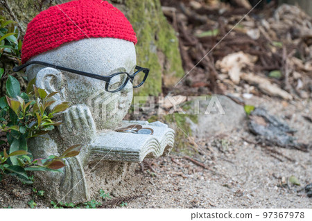 Cute Jizo wearing glasses and reading a book at Daishoin Temple in Miyajima, Hiroshima Cute Jizo wearing glasses and reading a book at Daishoin Temple in Miyajima, Hiroshima 97367978