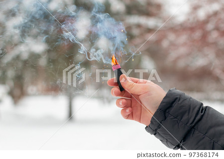 Burning Firecracker in a Hand. Sparks and Smoke of Petard Burning Firecracker in a Hand. Sparks and Smoke of Petard 97368174
