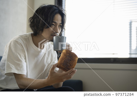 Young man eating toast 97371284