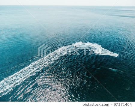 High speed water bike leaving abstract white footprints on the sea water. Aerial top view on Water scooter. Amazing nature background. Water color are beautifully vibrant. Fresh freedom. Adventure day 97371404