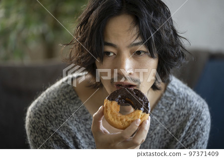 young man eating a donut 97371409