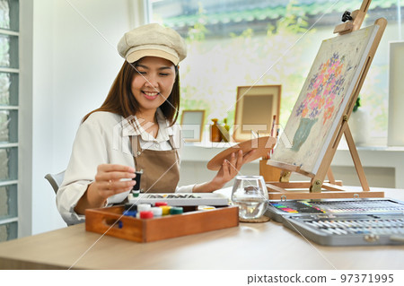 Pretty young woman creating artwork with watercolor, enjoy creativity activity at home. Art and leisure activity concept Pretty young woman creating artwork with watercolor, enjoy creativity activity at home. Art and leisure activity concept 97371995