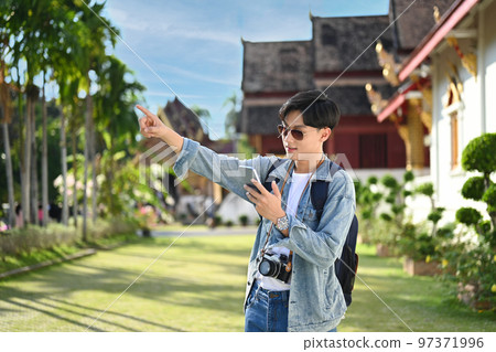 Hipster male traveler searching direction on smart phone. Life, people, travel and technology concept Hipster male traveler searching direction on smart phone. Life, people, travel and technology concept 97371996
