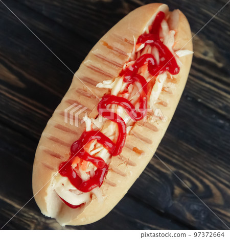 hot dog with spicy sauce on dark background.photo with copy space 97372664