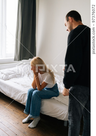 Vertical shot of frustrated blonde female tired of argument ignore irritate husband shouting at girlfriend. Stressed wife annoyed with jealous boyfriend. Couple quarrelling yelling at home. Vertical shot of frustrated blonde female tired of argument ignore irritate husband shouting at girlfriend. Stressed wife annoyed with jealous boyfriend. Couple quarrelling yelling at home. 97376072