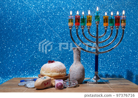 Jewish holiday Hanukkah background with menorah and dreidel with letters Gimel and Nun. 97376716