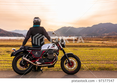 "Saitama Prefecture" A rider looking at the sunset while traveling 97377547