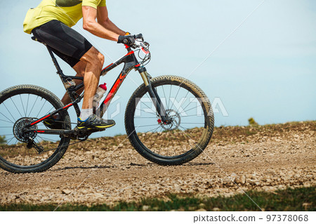 male athlete on mountainbike riding trail on background sky 97378068