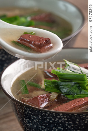 Eating Taiwanese traditional pig's blood soup with pickled mustard greens. 97378246