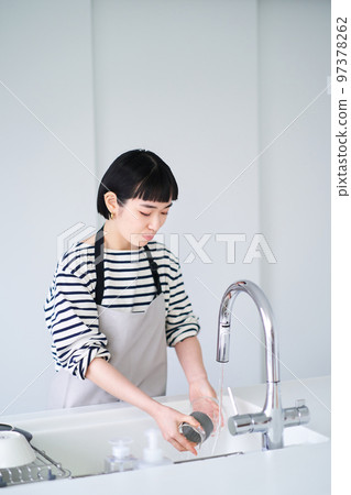 Woman washing dishes in the kitchen 97378262