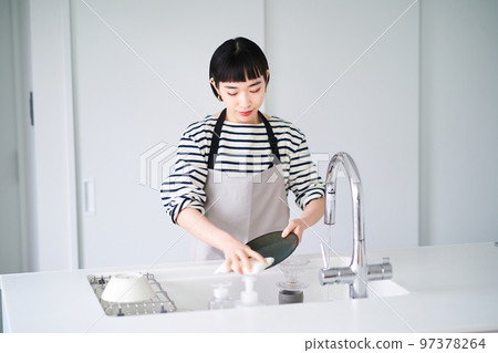 Woman washing dishes in the kitchen 97378264