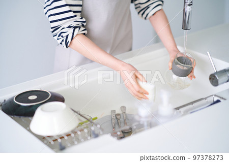 Woman washing dishes in the kitchen Woman washing dishes in the kitchen 97378273