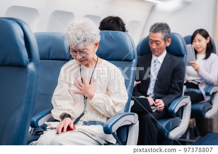 An elderly woman suffering from poor physical condition on an airplane 97378807