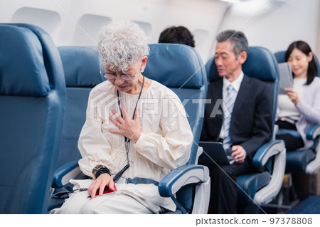 An elderly woman suffering from poor physical condition on an airplane 97378808