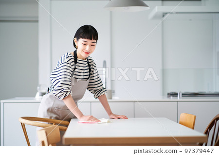 Young woman wiping the dining table Young woman wiping the dining table 97379447