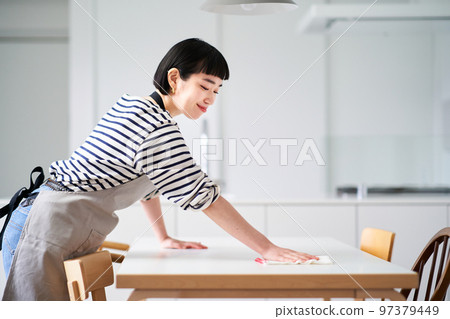 Young woman wiping the dining table 97379449
