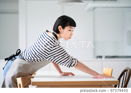 Young woman wiping the dining table 97379450