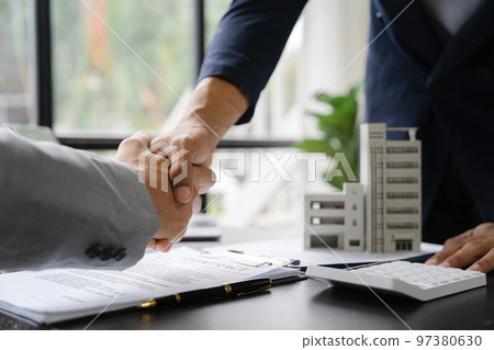 Close up shake hands, Considering buying a home, investing in real estate. Broker signs a sales agreement. agent, lease agreement, successful deal. Close up shake hands, Considering buying a home, investing in real estate. Broker signs a sales agreement. agent, lease agreement, successful deal. 97380630