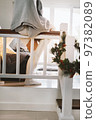 Beautiful woman gray blanket staying at home during cold weather Christmas wreath stairs Decoration 97382089