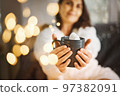 Woman with mug cocoa marshmallows sitting on couch in cozy warm winter season Winter holidays spirit 97382091