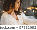 Cute brunette millenial woman enjoying Christmas atmosphere in the most cozy season of year at home 97382092