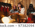 Gift Giving Happy interracial couple celebrating New Year Christmas at home opening gifts 97382094
