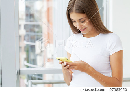 Lazy woman relax in the office hold smart phone use apps Lazy woman relax in the office hold smart phone use apps 97383050