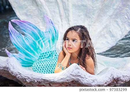 A beautiful girl in a mermaid costume in a large sea shell 97383299