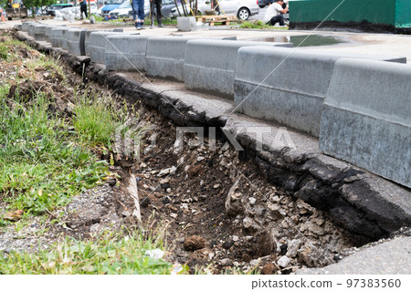 New curbs stand at the edge of the sidewalk. Preparing to repair road New curbs stand at the edge of the sidewalk. Preparing to repair road 97383560