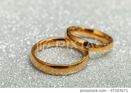 Will you marry me. Two golden wedding rings on silver glitter background. Engagement marriage proposal wedding concept. St. Valentine's Day postcard. Banner on valentines day. Copy space 97383671