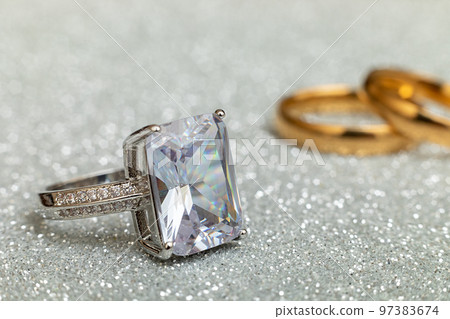 Will you marry me. Engagement ring and two wedding rings on silver glitter background. Engagement marriage proposal wedding concept. St. Valentine's Day postcard. Banner on valentines day. Copy space Will you marry me. Engagement ring and two wedding rings on silver glitter background. Engagement marriage proposal wedding concept. St. Valentine's Day postcard. Banner on valentines day. Copy space 97383674