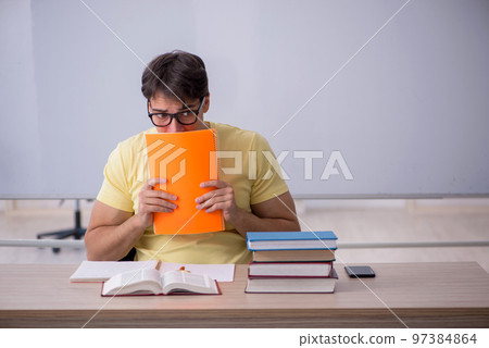 Young male student sitting in the classroom 97384864