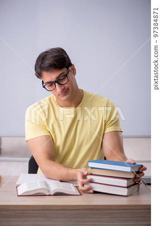 Young male student sitting in the classroom Young male student sitting in the classroom 97384871