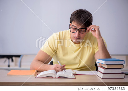 Young male student sitting in the classroom Young male student sitting in the classroom 97384883