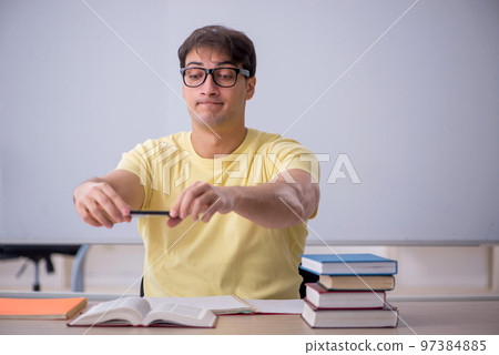 Young male student sitting in the classroom Young male student sitting in the classroom 97384885